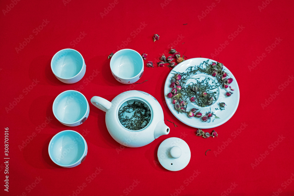 Tea composition with Chinese traditional tea cups and teapot on the background of red velvet fabric. Tea composition with Chinese traditional tea cups and teapot on the background of red velvet fabric.