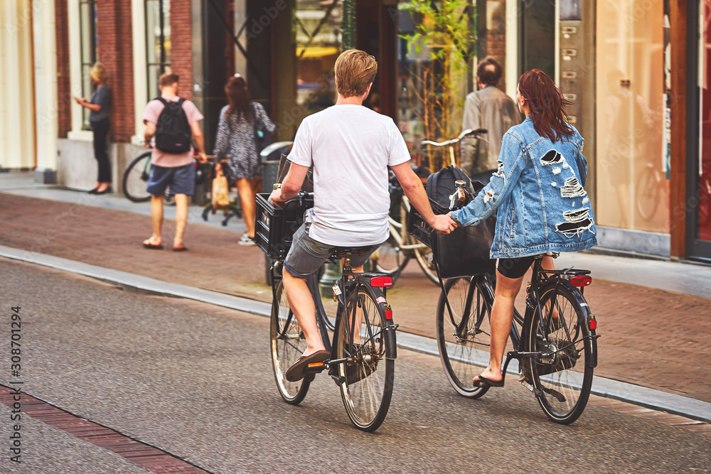 Obraz premium Young dutch couple on the bikes holding hands