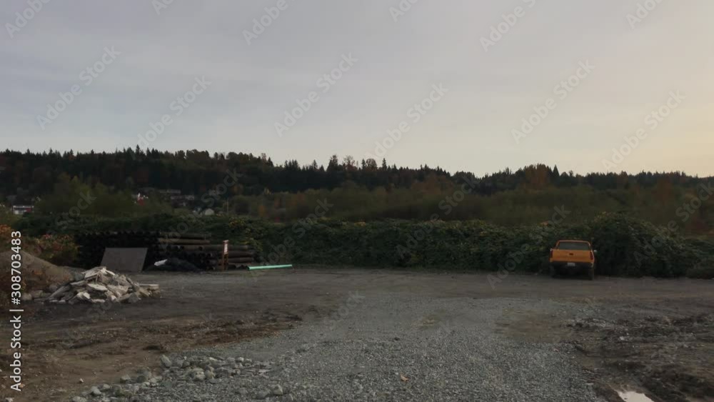 Gravel and construction open scene with trees and bushes in the background. Gravel and construction open scene with trees and bushes in the background.