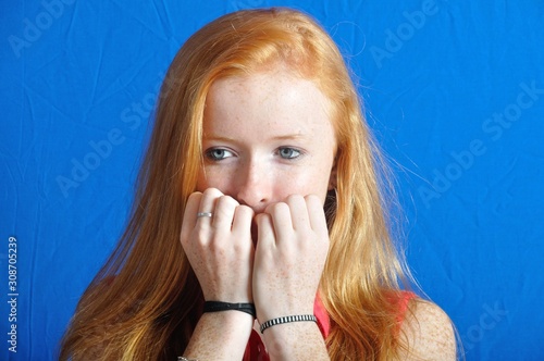 фотографія Scared teen on blue background