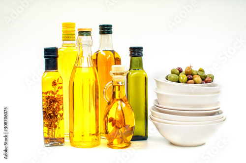 Various bottles with olive oil on a white background