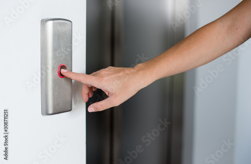 Woman's hand is pressing elevator button. Close-up Of Female's Hand Pressing Button In Elevator.