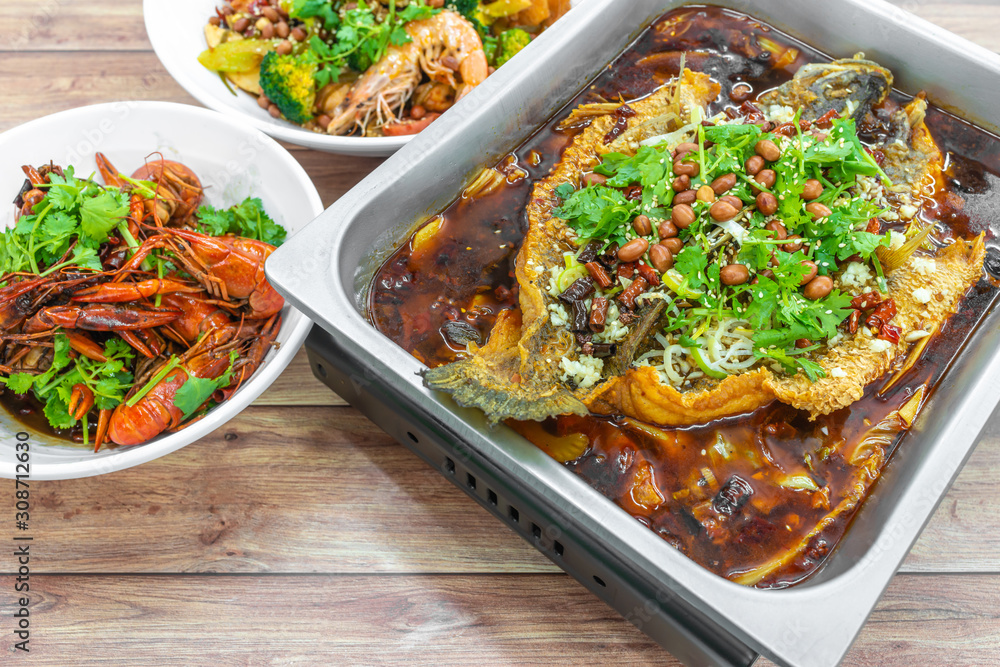 Sichuan Grilled Fish in red spicy oil, and mini lobsters. Authentic China, Chinese Szechuan Chongqing food on table. Sichuan Grilled Fish in red spicy oil, and mini lobsters. Authentic China, Chinese Szechuan Chongqing food on table.