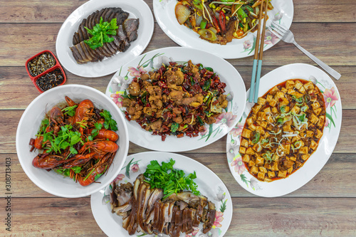 Flat lay top down view of table of authentic China Sichuan Hunan food. Assorted traditional dishes such as Fragrant Hotpot, crispy fried chicken, mini lobsters, spicy bean curd mapo doufu.