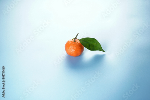 Flat lay fresh orange mandarin with leaves, on a bluel background.