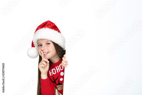 Little girl in christmas sweater and hat with blank board on white background