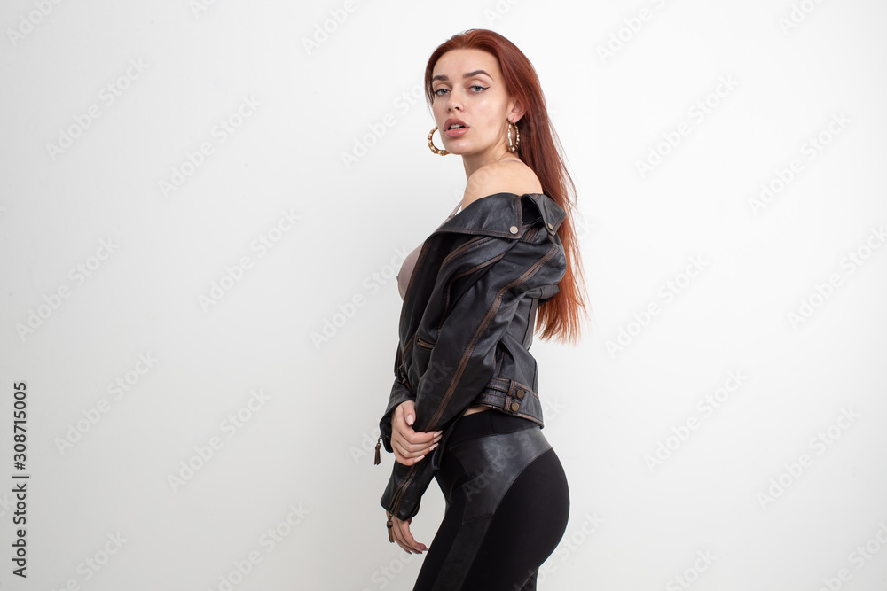 Sexy redhead girl posing in leather jacket on white background Sexy redhead girl posing in leather jacket on white background