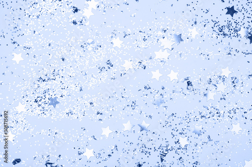 confetti and stars and sparkles on Classic Blue Christmas background. Top view, flat lay. Copyspace for text. Bright and festive holiday background. Color of year 2020.