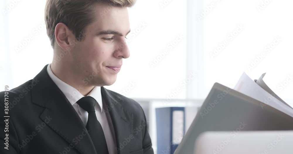 Businessman satisfied on analyzing documents at work Businessman satisfied on analyzing documents at work