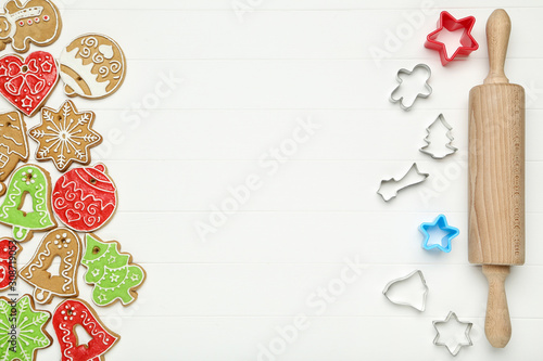 Christmas gingerbread cookies with kitchen utensils on white wooden table