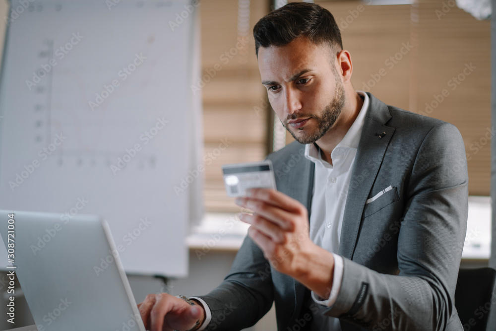 Paying bills online. Businessman in office. Handsome businessman using e-banking. Paying bills online. Businessman in office. Handsome businessman using e-banking.
