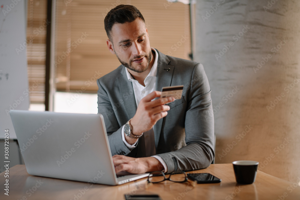 Paying bills online. Businessman in office. Handsome businessman using e-banking. Paying bills online. Businessman in office. Handsome businessman using e-banking.
