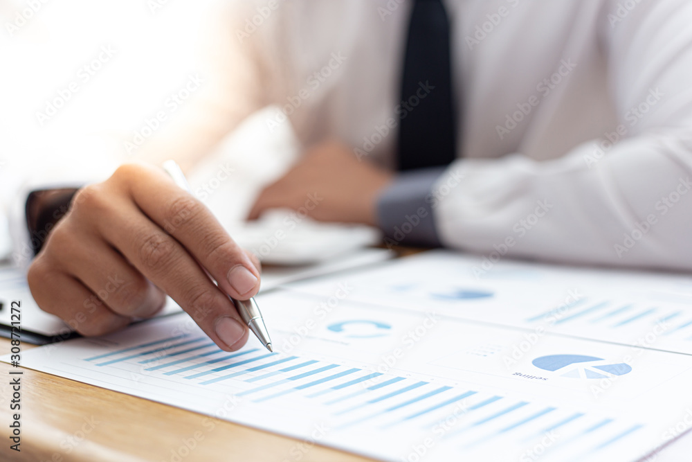 Business men use calculators to calculate the company's tax and revenue in the office, Financial and accounting banking concepts. Business men use calculators to calculate the company's tax and revenue in the office, Financial and accounting banking concepts.
