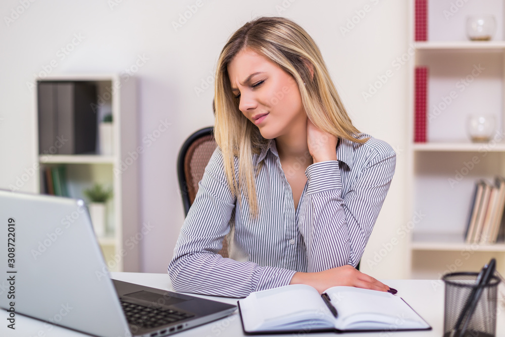 Businesswoman having neck pain while working in her office. Businesswoman having neck pain while working in her office.