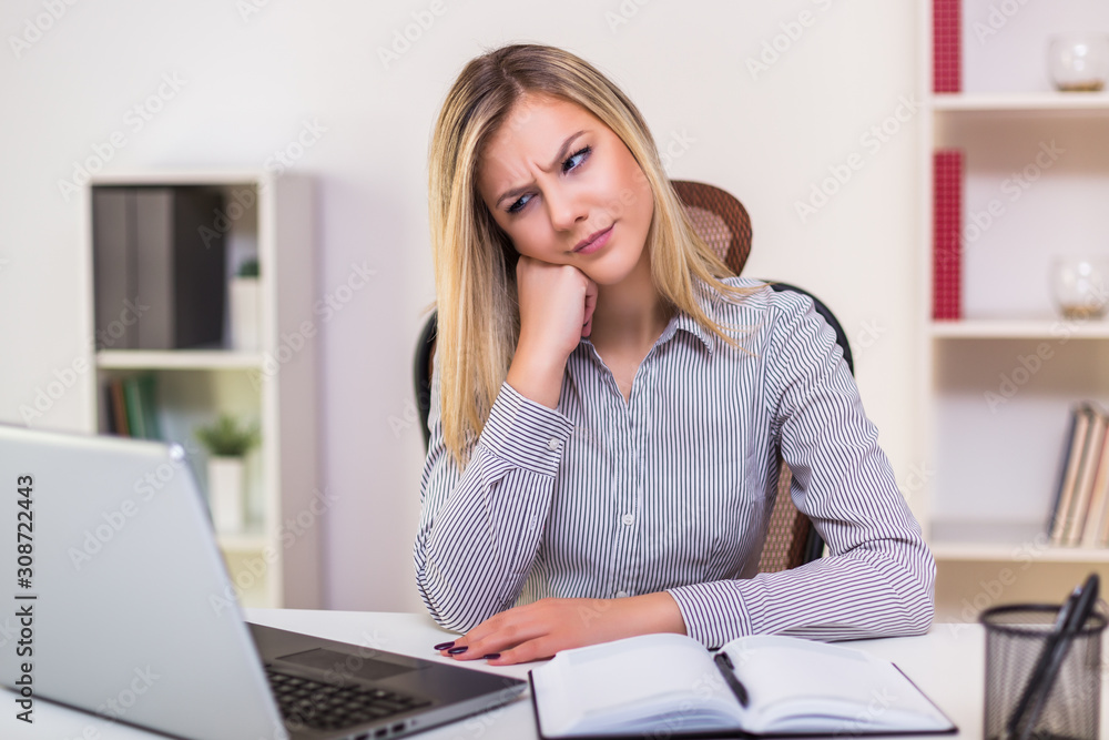Angry businesswoman sitting in her office and working. Angry businesswoman sitting in her office and working.