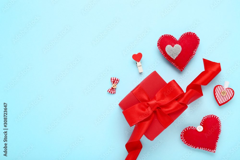 Red fabric hearts with gift box on blue background