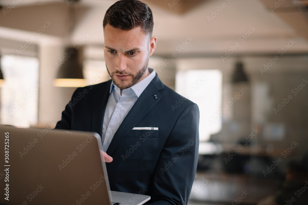 Portrait of handsome businessman. Man with his lap top in office. Portrait of handsome businessman. Man with his lap top in office.