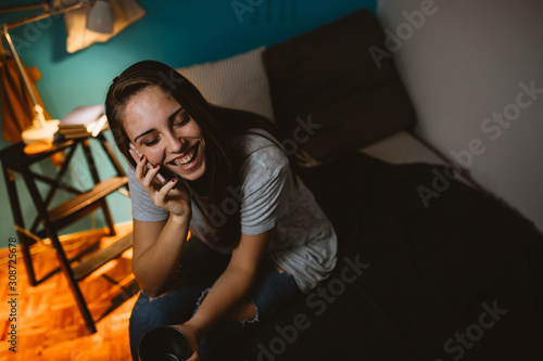 woman talking on mobile phone in her room, night scene