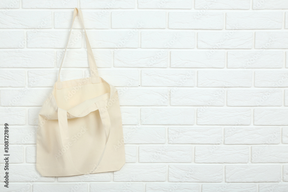 White cotton eco bag on brick wall background White cotton eco bag on brick wall background