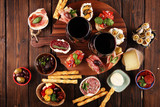 Appetizers table with italian antipasti snacks and wine in glasses. Brushetta or authentic traditional spanish tapas set, cheese variety