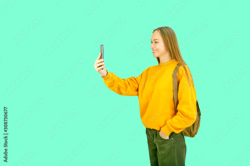 Young woman in white backpack travel and take selfie on camera smartphone. Young woman in white backpack travel and take selfie on camera smartphone.