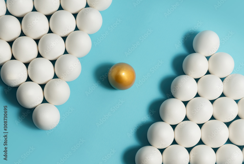 Concept of individuality, exclusivity, better choice. One golden egg among white eggs on blue background. Concept of individuality, exclusivity, better choice. One golden egg among white eggs on blue background.