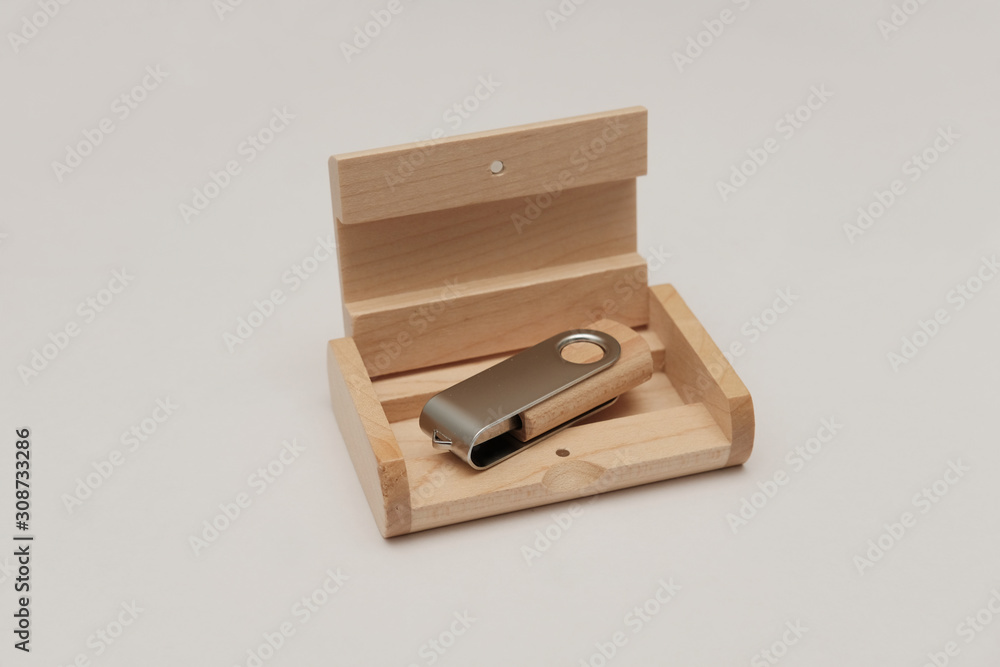 Wooden usb flash drive with a metal insert, lies in an open wooden box on an empty background Wooden usb flash drive with a metal insert, lies in an open wooden box on an empty background