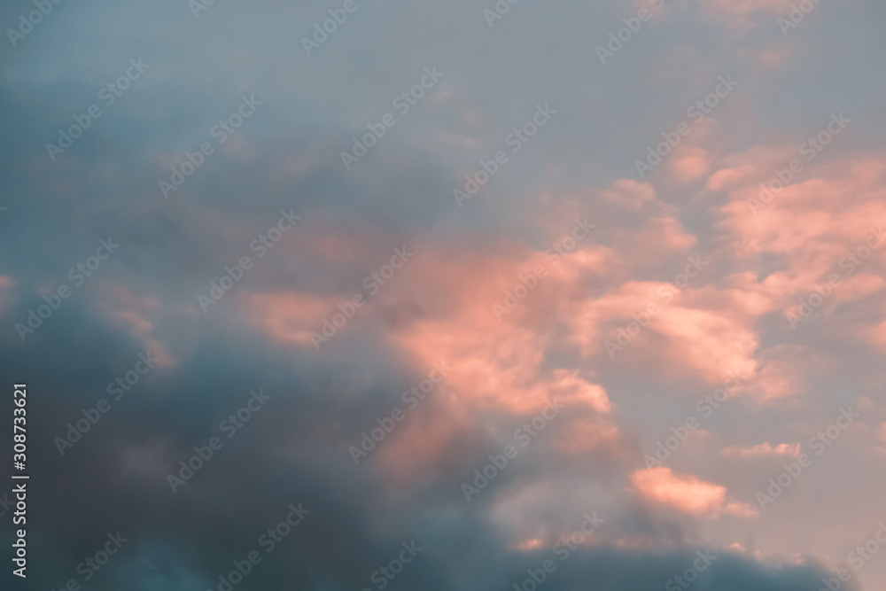 clouds with a pink tinge of sunset in a blue sky