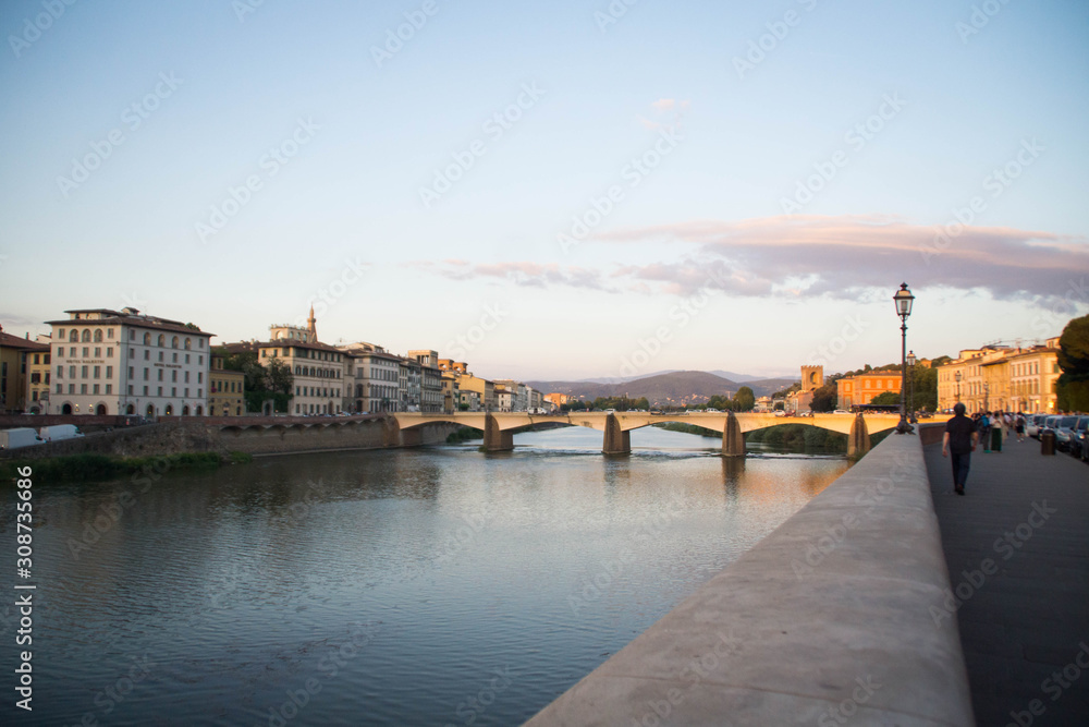 View over a bridge on Arno river at sunset. Florence, Tuscany, Italy.