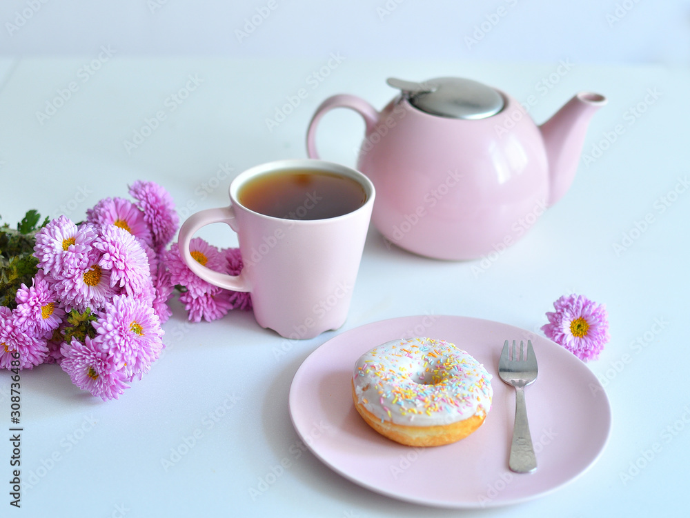 pink teapot, cup of tea and colorful delicious doughnuts