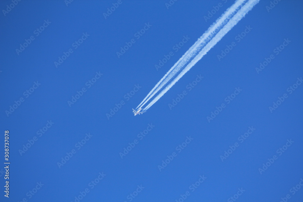 A plane flies through the blue sky. A plane flies through the blue sky.