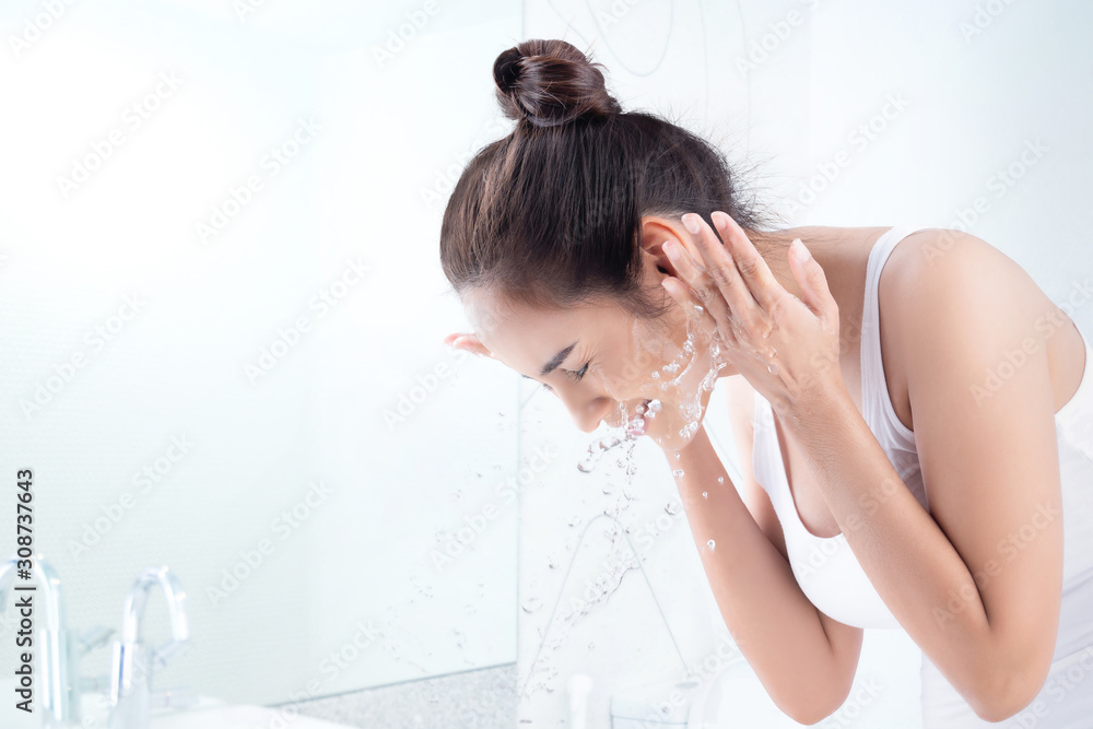 Fototapeta premium Beautiful woman washing face in the bathroom