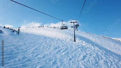 Ski lift runs over white slopes in the alps
