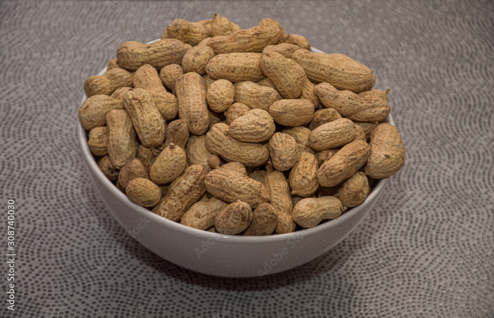 peanuts in bowl on wooden table peanuts in bowl on wooden table