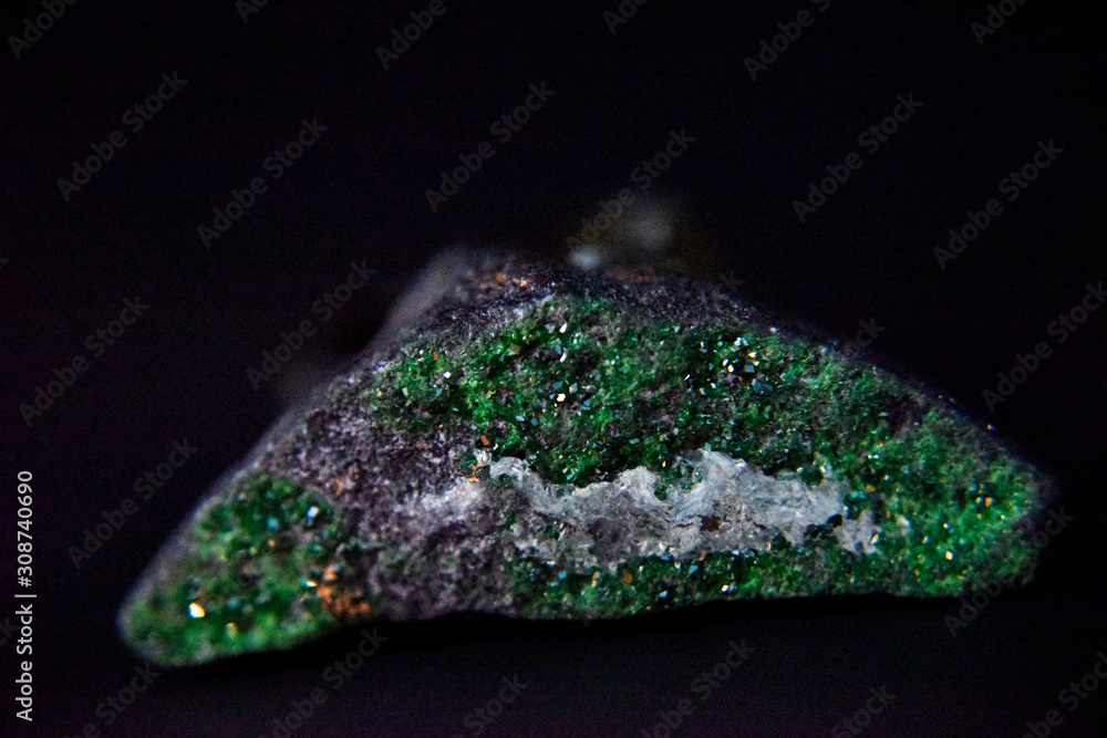 Emerald crystals on the dark background with the side light. Emerald crystals on the dark background with the side light.