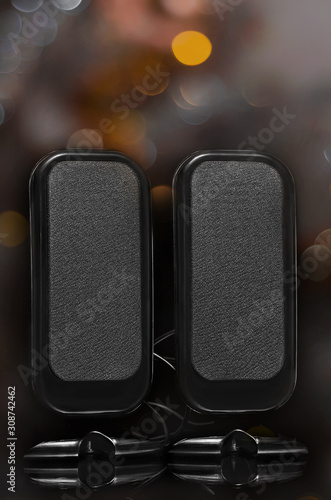 Portable sound speakers with black background with bokeh.