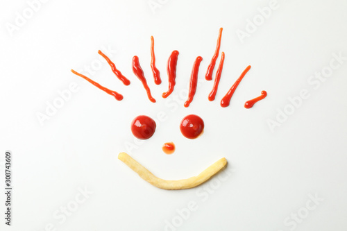 Handmade smiley face with tasty french and red sauce fries isolated on white background, top view
