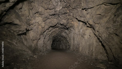 Speleology artificial cave dark tunnel excavation underground. Old adit for the extraction of metal and rocks