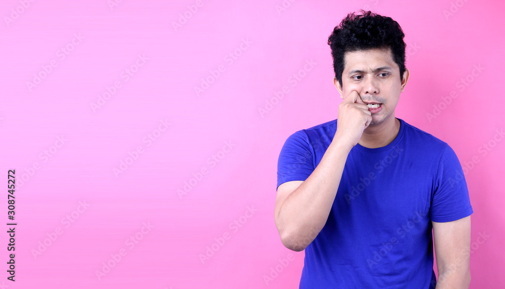 Portrait Young Asia man having doubts and with confuse face expression on pink background in studio With copy space. Portrait Young Asia man having doubts and with confuse face expression on pink background in studio With copy space.