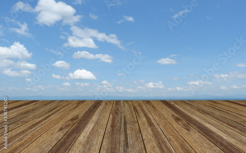 Perspective wooden board empty table top over blue sky with cloudy . Can be used for montage or display your products.