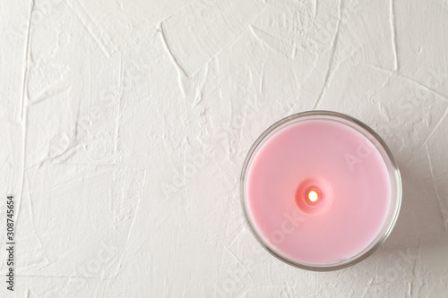 Pink candle in glass jar on white background, top view photo