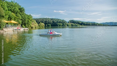 Couple paddle on idyllic lake Smartinsko, Slovenia. Handheld photo