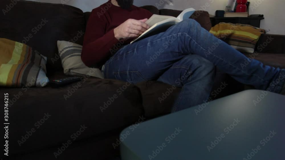 a man sitting on the couch relaxes reading a book a man sitting on the couch relaxes reading a book