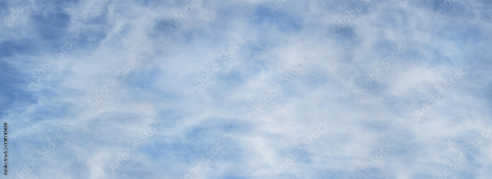 Abstract background based on clouds of uncertain shape in light blue sky_