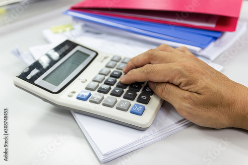 Employees use office calculators with documents of income, expenses, concept of life at work.