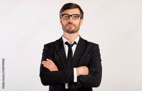 Serious Businessman Standing Crossing Hands On White Background