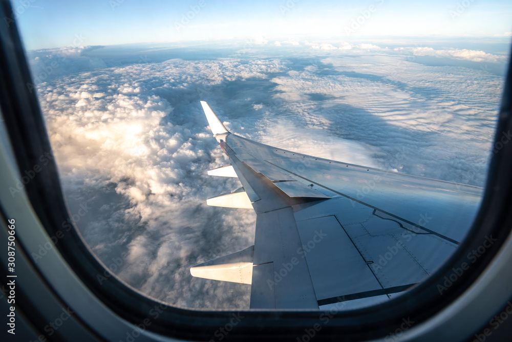 Silhouette wing of an airplane at sunrise view through the window.