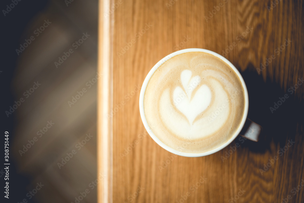 Cup of cappuccino with latte art on wooden table. Top view. Cup of cappuccino with latte art on wooden table. Top view.
