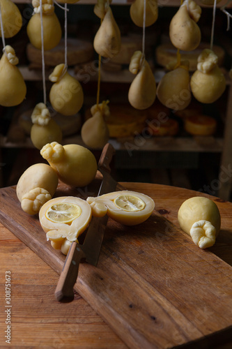 Sliced head of Italian hard cheese Scamorza or Caciocavallo with lime. caciocavallo - Italian cheese made from cow's or sheep's milk, closeup.