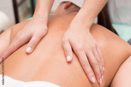 masseur makes massage to a beautiful girl. Spa pleasure